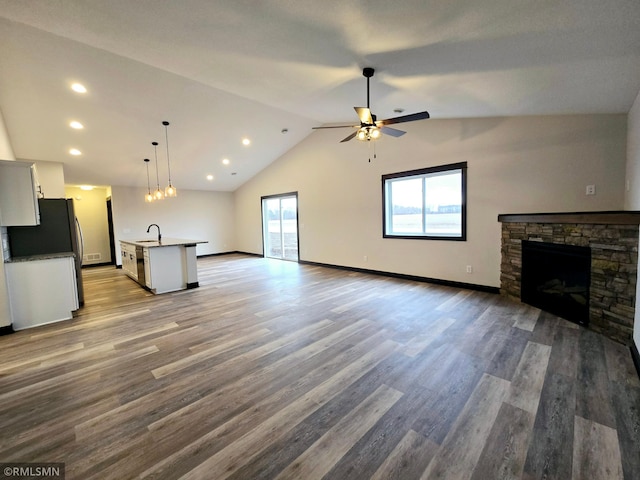 2001 Essler Dr, Saint Peter, MN 56082 - unfurnished living room with a fireplace, ceiling fan, lofted ceiling, wood finished floors, and recessed lighting