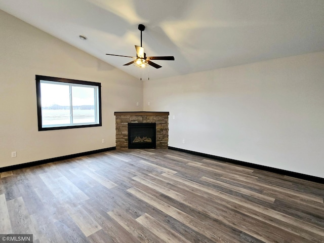 2001 Essler Dr, Saint Peter, MN 56082 - unfurnished living room with ceiling fan, vaulted ceiling, wood finished floors, and a stone fireplace