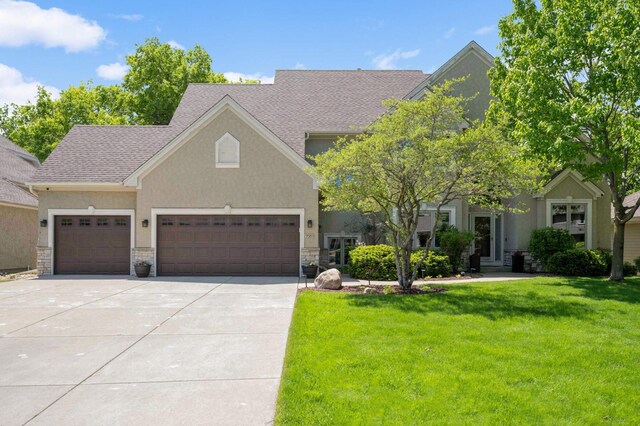 3583 Woodland Trl, Eagan, MN 55123 - view of front facade featuring a front lawn, driveway, an attached garage, stucco siding, and stone siding