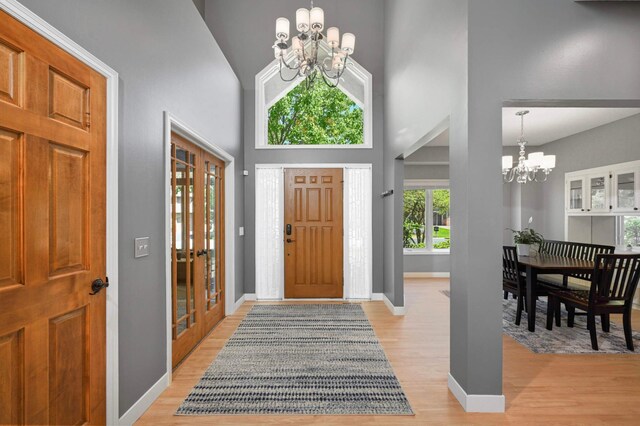 3583 Woodland Trl, Eagan, MN 55123 - entrance foyer featuring a chandelier, plenty of natural light, light wood-type flooring, high vaulted ceiling, and french doors