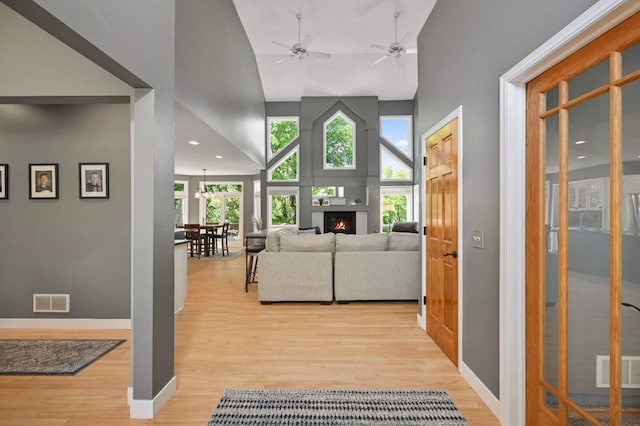 3583 Woodland Trl, Eagan, MN 55123 - living room with high vaulted ceiling, light wood-type flooring, a ceiling fan, a large fireplace, and recessed lighting