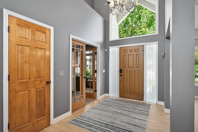 3583 Woodland Trl, Eagan, MN 55123 - entrance foyer with a chandelier, light wood-style flooring, and a high ceiling