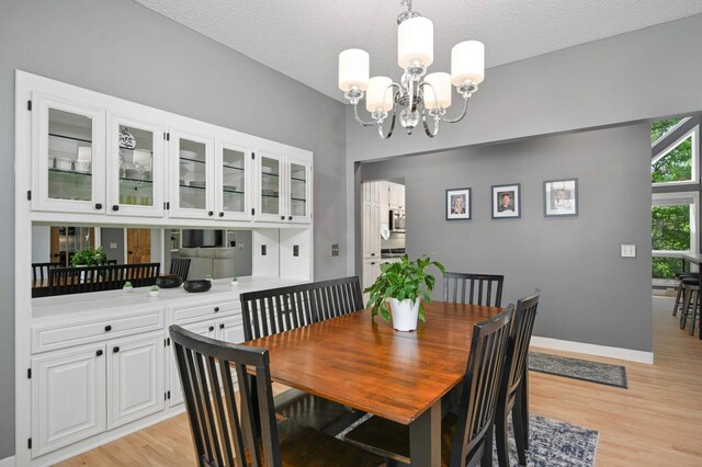3583 Woodland Trl, Eagan, MN 55123 - dining area featuring light wood finished floors, a chandelier, and a textured ceiling