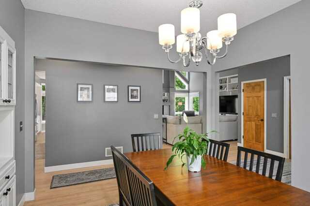 3583 Woodland Trl, Eagan, MN 55123 - dining space with a chandelier, light wood-type flooring, a textured ceiling, and built in shelves