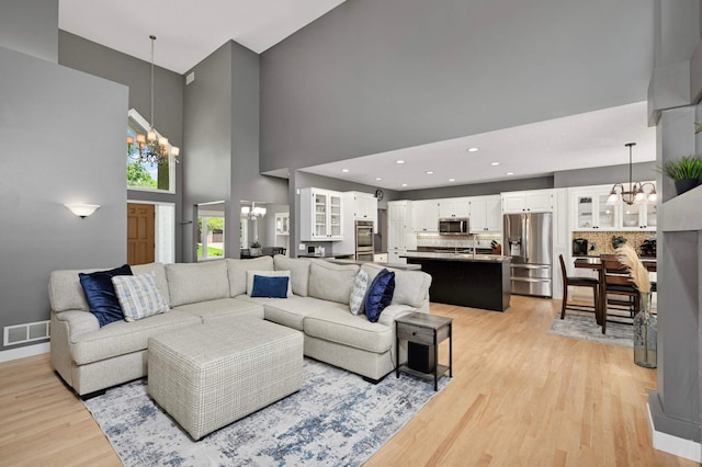 3583 Woodland Trl, Eagan, MN 55123 - living area featuring a chandelier, a high ceiling, and light wood-style floors
