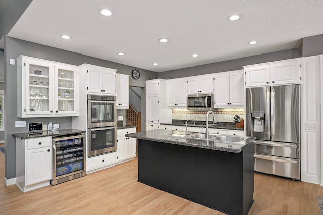 3583 Woodland Trl, Eagan, MN 55123 - kitchen featuring appliances with stainless steel finishes, beverage cooler, light wood-type flooring, recessed lighting, and decorative backsplash