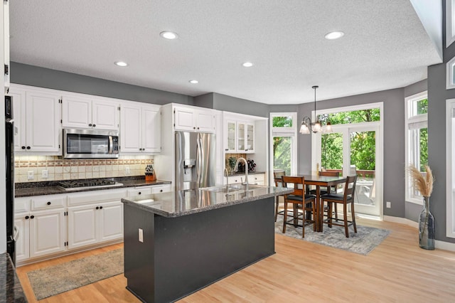 3583 Woodland Trl, Eagan, MN 55123 - kitchen featuring appliances with stainless steel finishes, a textured ceiling, tasteful backsplash, light wood-style flooring, and white cabinets