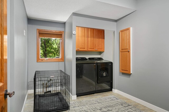 3583 Woodland Trl, Eagan, MN 55123 - laundry area with washer and clothes dryer, cabinet space, and a textured ceiling