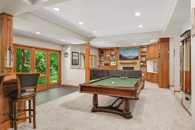 3583 Woodland Trl, Eagan, MN 55123 - recreation room with a textured ceiling, recessed lighting, a fireplace, decorative columns, and light colored carpet