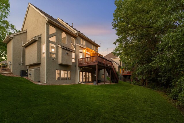 3583 Woodland Trl, Eagan, MN 55123 - back of property at dusk featuring a deck, stairway, a lawn, and stucco siding