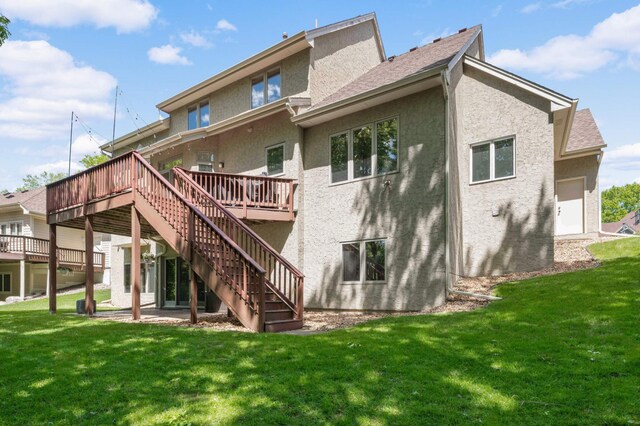 3583 Woodland Trl, Eagan, MN 55123 - rear view of house with stucco siding, stairs, a wooden deck, and a lawn