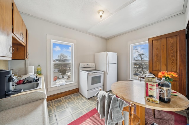 216 Elm St, River Falls, WI 54022 - kitchen with white appliances, light floors, and brown cabinetry