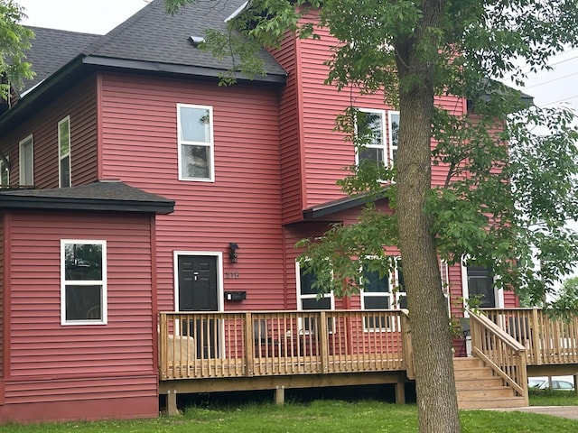 216 Elm St, River Falls, WI 54022 - rear view of property featuring a shingled roof and a wooden deck