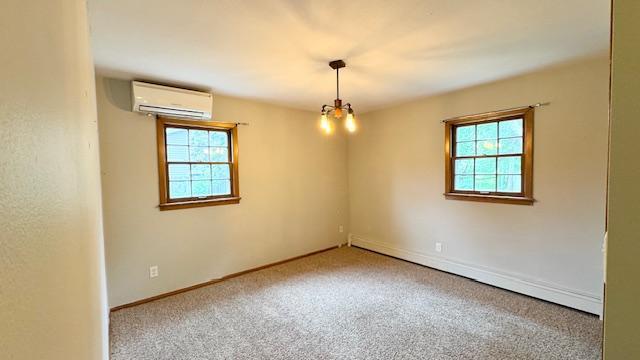 811 Myrtle St, Buffalo, MN 55313 - carpeted spare room featuring a wall mounted AC, plenty of natural light, a baseboard heating unit, and a chandelier