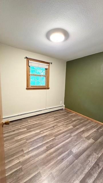 811 Myrtle St, Buffalo, MN 55313 - empty room featuring a baseboard radiator, wood finished floors, and a textured ceiling