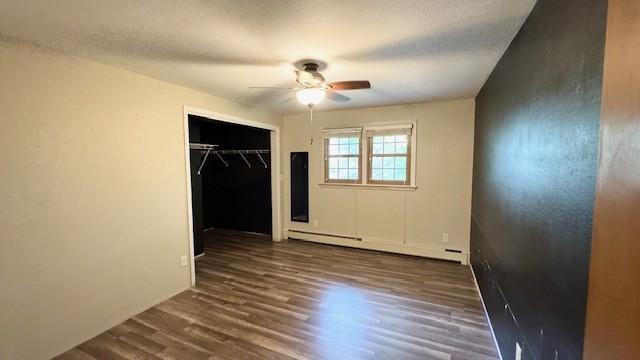 811 Myrtle St, Buffalo, MN 55313 - unfurnished bedroom with a baseboard heating unit, wood finished floors, a closet, and a ceiling fan