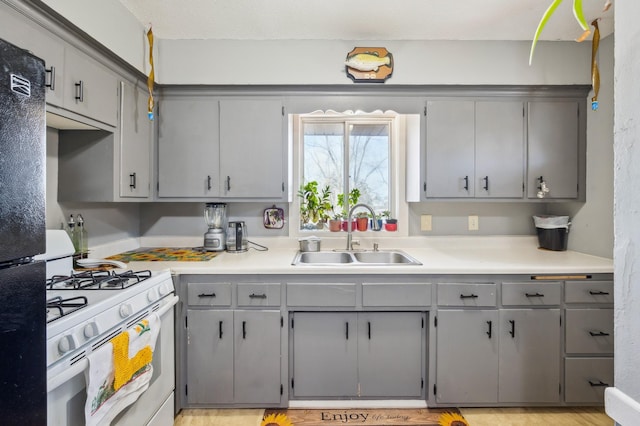 4638 Johnson St NE, Columbia Heights, MN 55421 - kitchen with white gas range oven, gray cabinetry, freestanding refrigerator, and light countertops