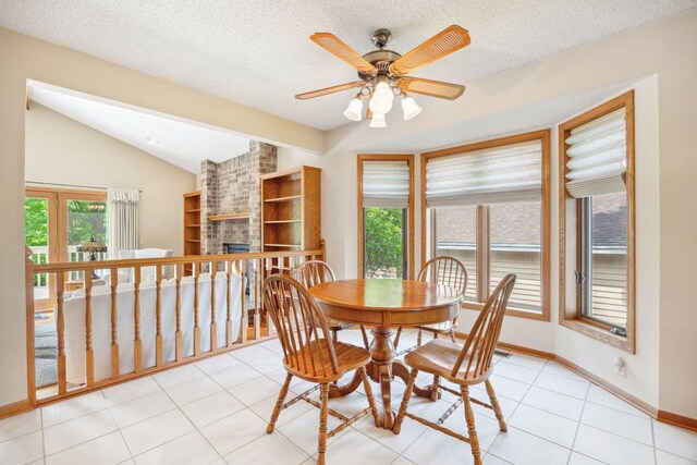 2017 87th Trl N, Brooklyn Park, MN 55443 - dining space with vaulted ceiling, ceiling fan, a fireplace, a textured ceiling, and light tile patterned flooring