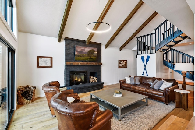 6641 Halstead Ave, Mound, MN 55364 - living room with wood finished floors, high vaulted ceiling, beamed ceiling, stairs, and a brick fireplace