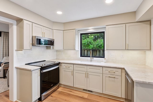 6641 Halstead Ave, Mound, MN 55364 - kitchen with stainless steel appliances, light wood finished floors, tasteful backsplash, recessed lighting, and light stone counters