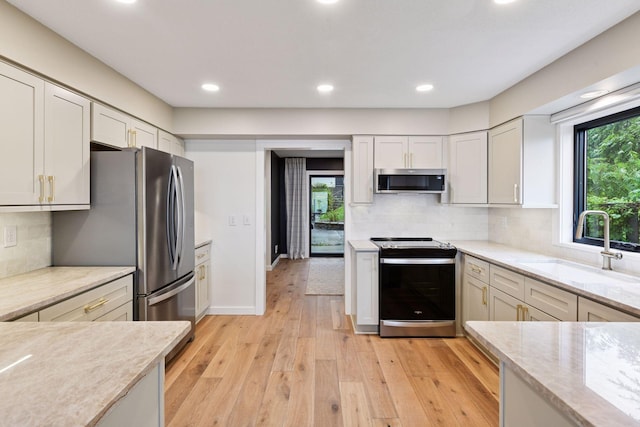 6641 Halstead Ave, Mound, MN 55364 - kitchen with stainless steel appliances, light wood-type flooring, recessed lighting, decorative backsplash, and light stone counters