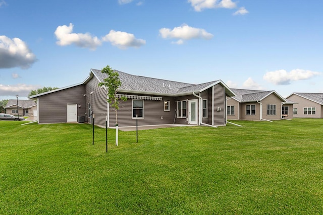 755 Escalade Ln SE, Owatonna, MN 55060 - back of property featuring a yard, a shingled roof, and a patio area