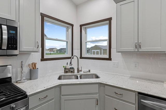 755 Escalade Ln SE, Owatonna, MN 55060 - kitchen with stainless steel appliances, tasteful backsplash, and light stone countertops