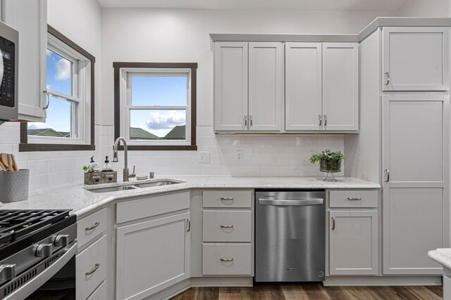 755 Escalade Ln SE, Owatonna, MN 55060 - kitchen with stainless steel appliances, backsplash, dark wood-style floors, and light stone countertops