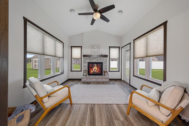 755 Escalade Ln SE, Owatonna, MN 55060 - living room featuring lofted ceiling, wood finished floors, ceiling fan, and a stone fireplace