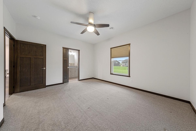 755 Escalade Ln SE, Owatonna, MN 55060 - unfurnished bedroom featuring light colored carpet, ensuite bath, and a ceiling fan