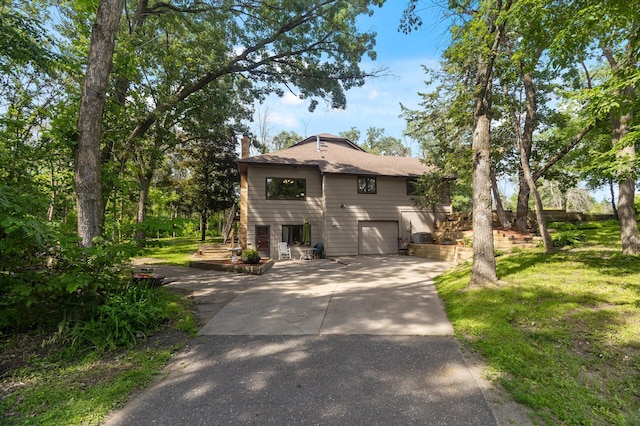 17208 Woodbine St NW, Andover, MN 55304 - view of front of property featuring driveway, a garage, a chimney, and a front lawn