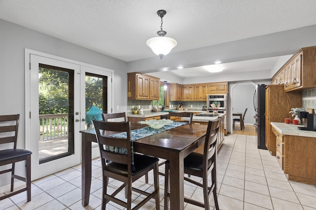 17208 Woodbine St NW, Andover, MN 55304 - dining space featuring light tile patterned flooring, a textured ceiling, and arched walkways