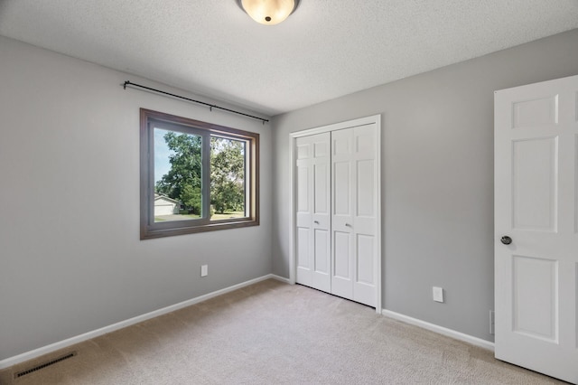 17208 Woodbine St NW, Andover, MN 55304 - unfurnished bedroom with light colored carpet, a closet, and a textured ceiling