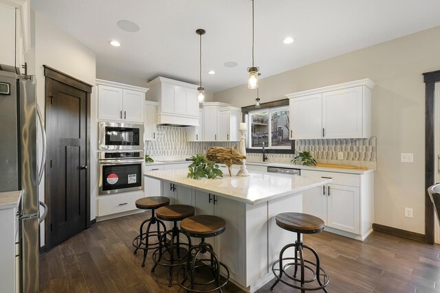 13566 Birdsong Path, Rosemount, MN 55068 - kitchen featuring stainless steel appliances, dark wood-style floors, a kitchen breakfast bar, white cabinets, and recessed lighting