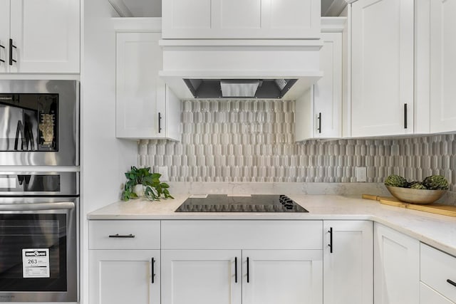 13566 Birdsong Path, Rosemount, MN 55068 - kitchen with black electric stovetop, stainless steel microwave, white cabinetry, and decorative backsplash