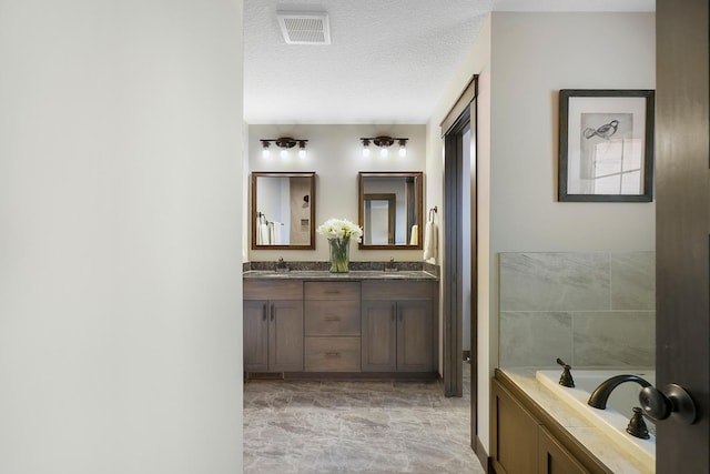 13566 Birdsong Path, Rosemount, MN 55068 - full bathroom featuring double vanity, a garden tub, marble finish flooring, and a textured ceiling