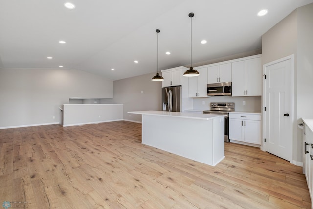 2600 74th Ave S, Fargo, ND 58104 - kitchen featuring appliances with stainless steel finishes, light wood-type flooring, white cabinetry, a kitchen island, and vaulted ceiling
