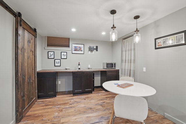 3826 Adair Ave N, Crystal, MN 55422 - bar area with stainless steel microwave, light wood finished floors, a barn door, recessed lighting, and decorative light fixtures