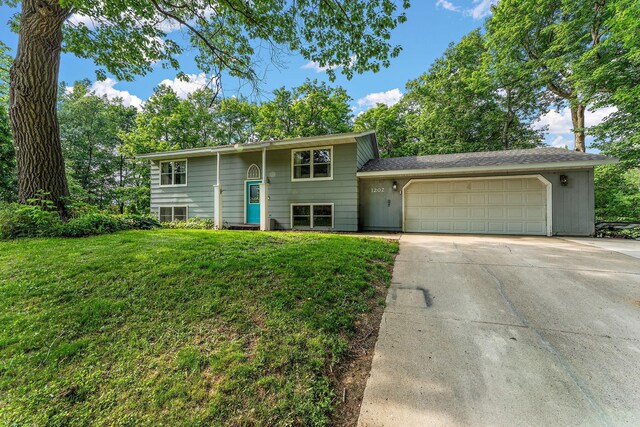 1202 Matteson St, Faribault, MN 55021 - raised ranch featuring a garage, driveway, and a front yard
