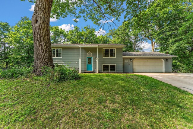 1202 Matteson St, Faribault, MN 55021 - split foyer home featuring an attached garage, driveway, and a front lawn