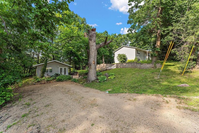 1202 Matteson St, Faribault, MN 55021 - view of green lawn with french doors and view of wooded area