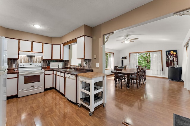 1202 Matteson St, Faribault, MN 55021 - kitchen featuring white appliances, under cabinet range hood, light wood-style floors, ceiling fan, and dark countertops