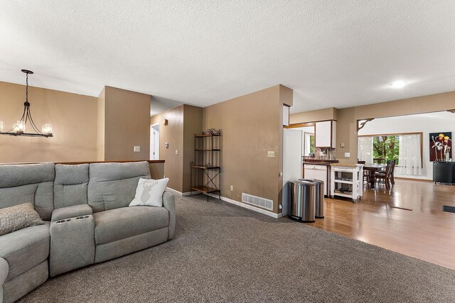 1202 Matteson St, Faribault, MN 55021 - living area featuring a chandelier, carpet flooring, and a textured ceiling