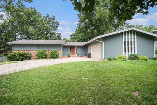 201 Elm St, Luverne, MN 56156 - mid-century modern home featuring a garage, a front yard, and driveway
