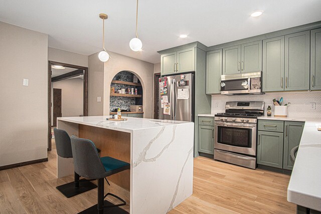 201 Elm St, Luverne, MN 56156 - kitchen with appliances with stainless steel finishes, green cabinetry, light wood-type flooring, decorative backsplash, and light stone counters