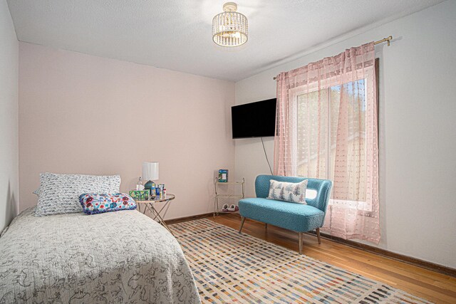 201 Elm St, Luverne, MN 56156 - bedroom featuring wood finished floors and a chandelier