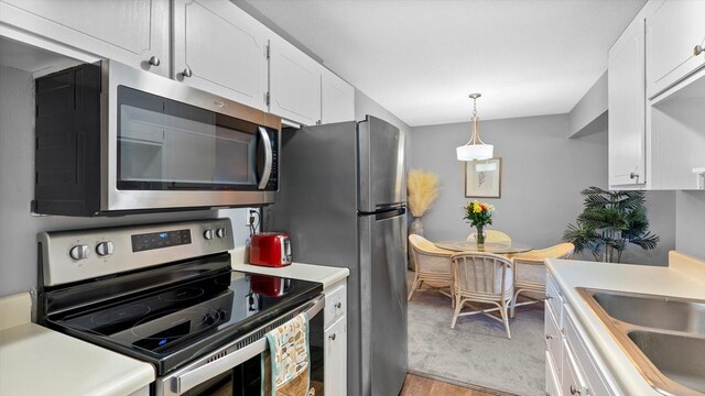4397 Wilshire Blvd # E305, Mound, MN 55364 - kitchen with stainless steel appliances, white cabinets, light countertops, and light wood-style floors