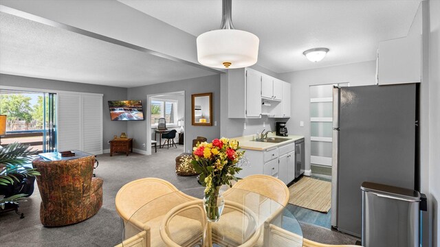 4397 Wilshire Blvd # E305, Mound, MN 55364 - kitchen with appliances with stainless steel finishes, light countertops, white cabinets, and light carpet