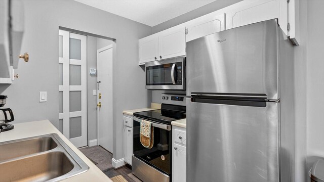 4397 Wilshire Blvd # E305, Mound, MN 55364 - kitchen featuring stainless steel appliances, light countertops, white cabinetry, and dark wood finished floors