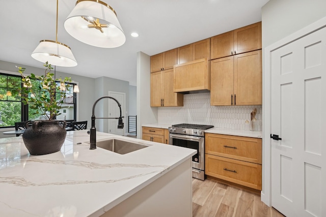 3909 54th St, Edina, MN 55424 - kitchen featuring stainless steel range with gas stovetop, backsplash, light wood-style floors, light stone countertops, and hanging light fixtures